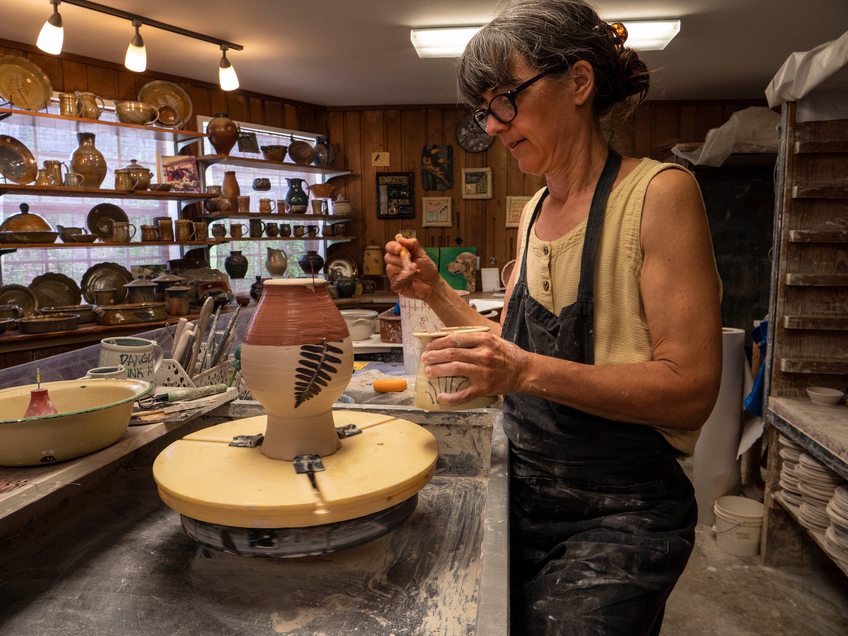Woman painting pottery at the Ozark Folk Center State Park Craft Village